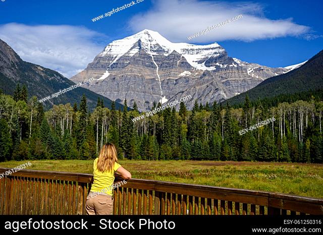 Woman watching the snow capped peak of Mount Robson, the highest peak in the Canadian Rockies in Mt. Robson Provincial Park, British Columbia, Canada