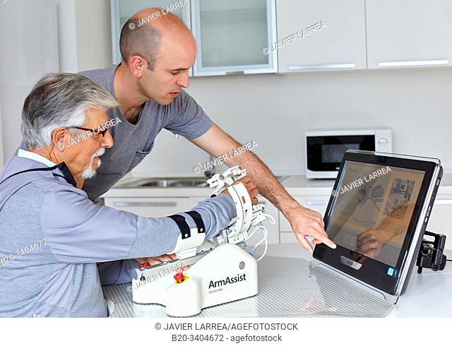 Patient with assistive robot for upper limb rehabilitation, The robot ArmAssist allows passive, assisted and active training of the arm and hand