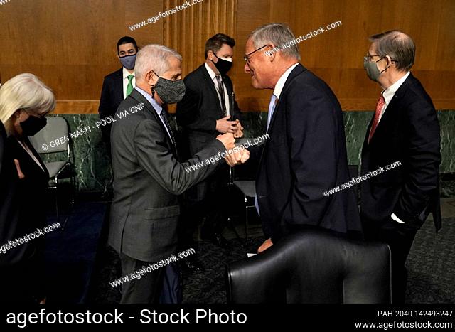 Dr. Anthony Fauci, director of the National Institute of Allergy and Infectious Diseases, fist bumps United States Senator Richard Burr (Republican of North...