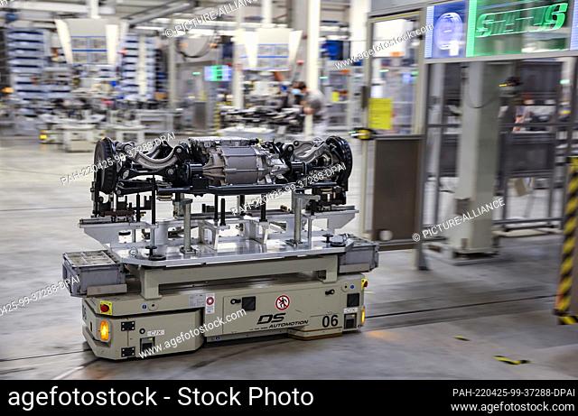 25 April 2022, Saxony, Meerane: A rear axle with electric motor for a Volkswagen electric vehicle moves fully automatically through the assembly hall