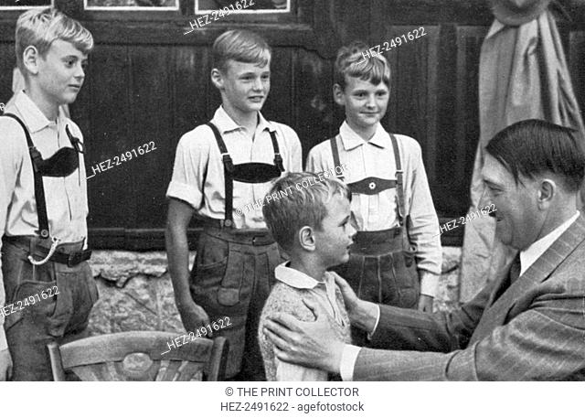 Four brothers meet Adolf Hitler, 1936. Hitler (1889-1945) with four young boys dressed in traditional Bavarian costume. A print from Adolf Hitler