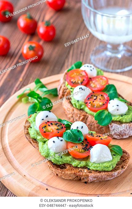 Sandwiches with avocado paste, cherry tomatoes and mozzarella