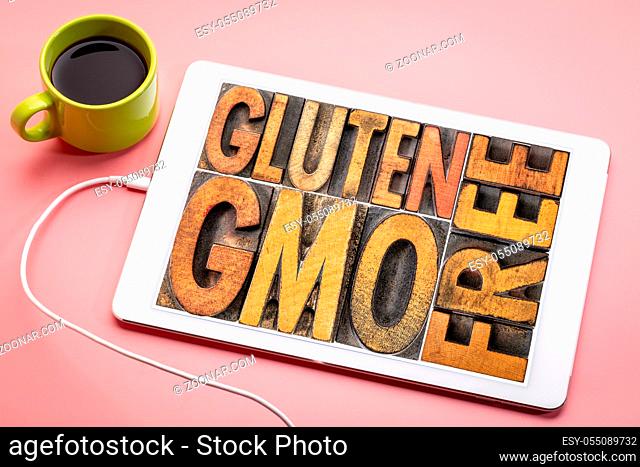 gluten and GMO (genetically modified organism) free banner - word abstract in vintage on a digital tablet with a cup of coffee