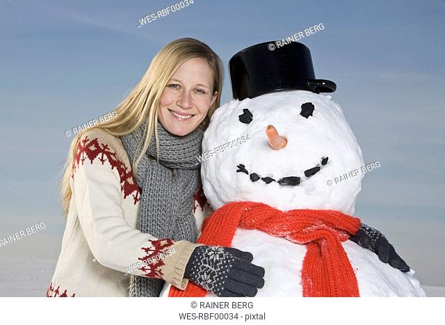 Germany, Bavaria, Munich, Woman hugging snowman