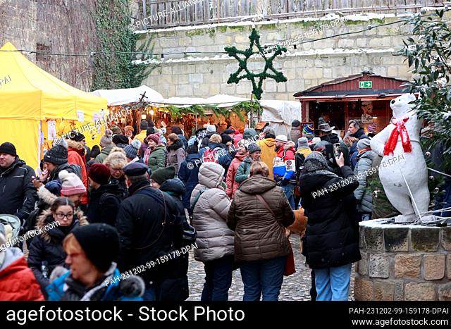 02 December 2023, Saxony-Anhalt, Quedlinburg: Visitors to Advent in den Höfen at a small Christmas market in a backyard. Advent in den Höfen has been around for...