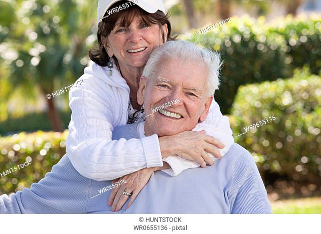 Portrait of a woman hugging a man from behind
