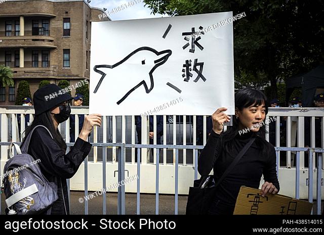 Activists hold signs protesting dolphin performances outside the Executive Yuan in Taipei, Taiwan on 13/12/2023 calling for the government to ban whale and...