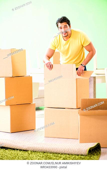 Young handsome man moving in to new house with boxes