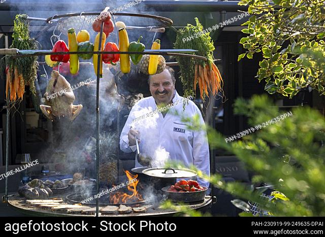 PRODUCTION - 15 September 2023, Rhineland-Palatinate, Bad Kreuznach: Johann Lafer, TV chef and book author, stands by an open wood-burning oven in his garden in...