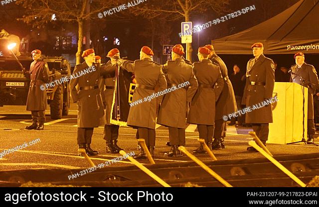 07 December 2023, Thuringia, Gera: Bundeswehr soldiers take the oath on the troop flag at the public pledge for approx. 100 recruits of the 5th company of the...