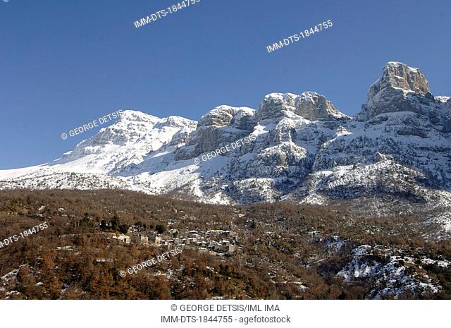 View of Mikro Papingo village and snowy mountains. Mikro Papingo, Ioannina, Epiros, Greece, Europe