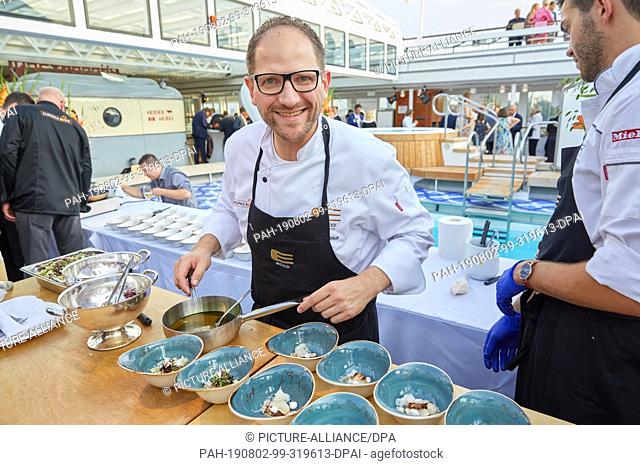 02 August 2019, Hamburg: Rolf Fliegauf, top chef, served during the gourmet event ""Europe's best"" on the luxury ship MS Europa Kingfisch with posed oyster...