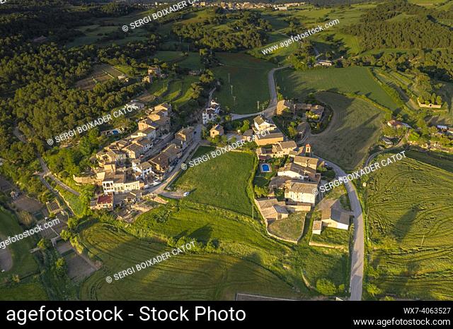 Aerial view of El Mujal village and its surrounding green fields in a spring sunset (Bages, Barcelona, Catalonia, Spain)