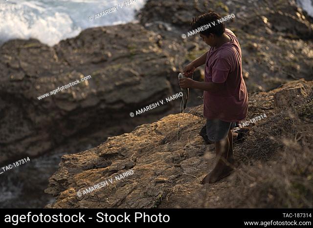 MAZUNTE, MEXICO - JUNE 9: People fishing for mojarras in the mountain at the western end of Mazunte beach known as Punta Cometa (kite tip) on June 9
