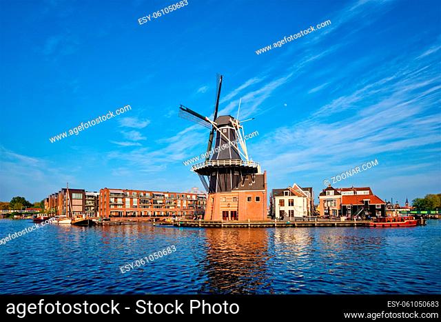 Harlem cityscape - landmark windmill De Adriaan on Spaarne river with boats. Harlem, Netherlands