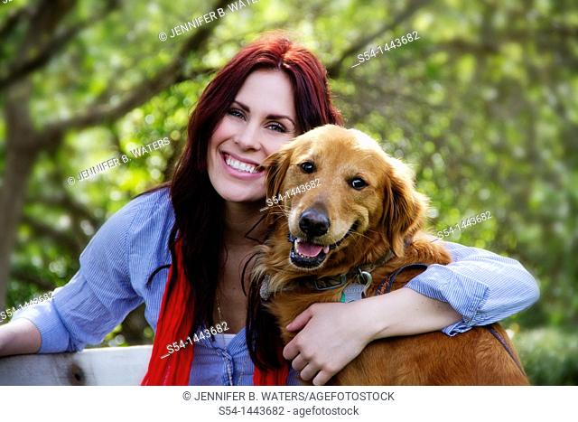 A woman outdoors with her Golden Retriever