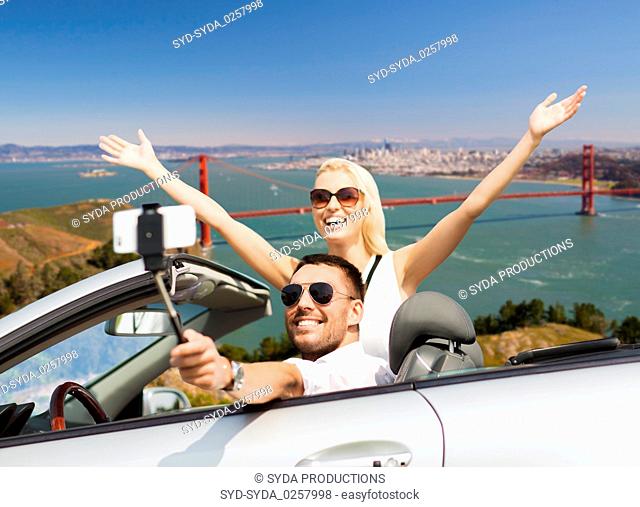 happy couple in car taking selfie by smartphone