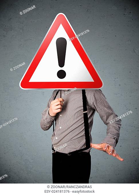 Businessman holding an exclamation road sign