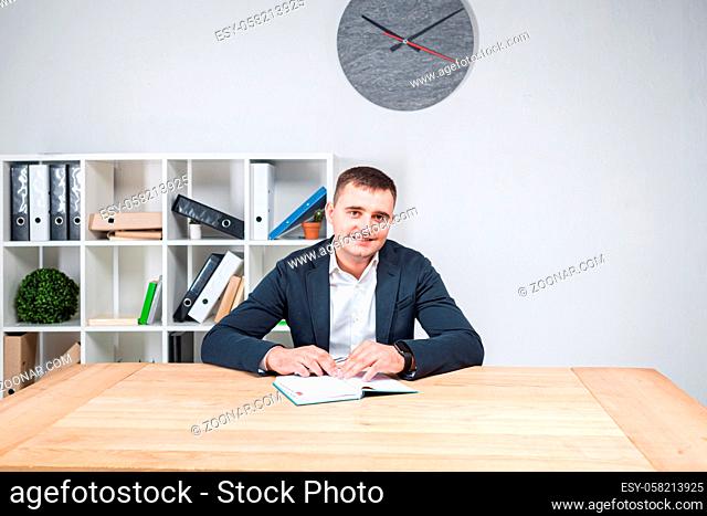 Portrait of a Caucasian male indoors posing in a jacket and white shirt. Overweight office worker at the workplace. The topic of obesity in sedentary inactive...