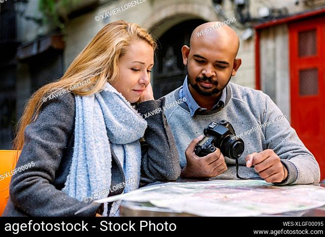 Portrait of couple looking at map, Barcelona, Spain