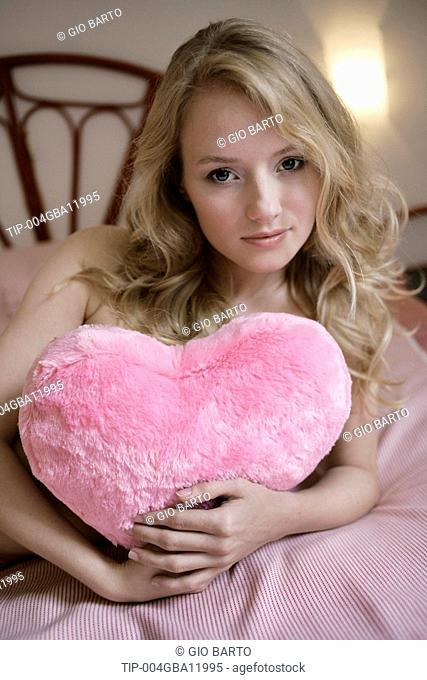 Portrait of woman holding plush pink heart