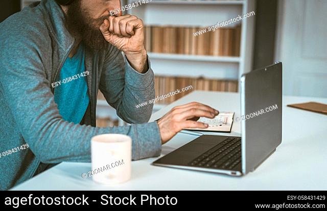 Sad European works in the Internet. A man thinks in front of a computer. The concept of choice. High quality photo