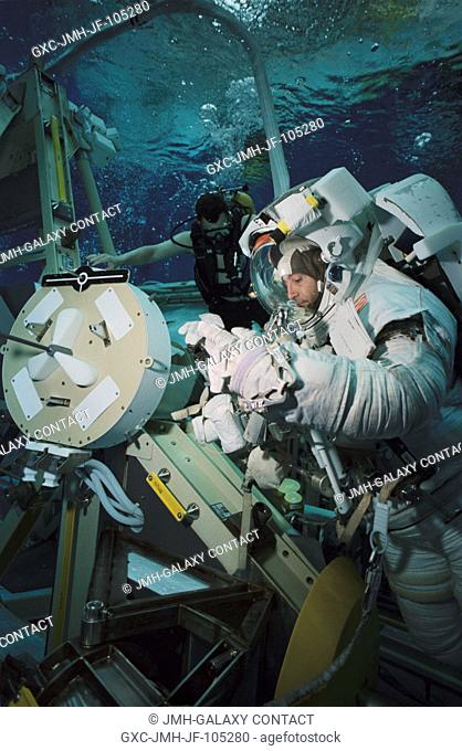 Astronaut Philippe Perrin, STS-111 mission specialist, wears a training version of the Extravehicular Mobility Unit (EMU) space suit during an underwater...