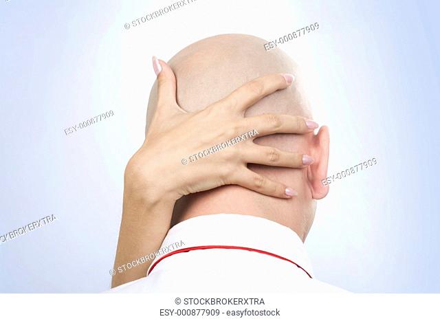 Image of females hand on back of males bald head