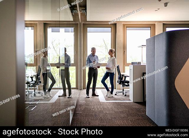 Businessman and businesswoman talking in office