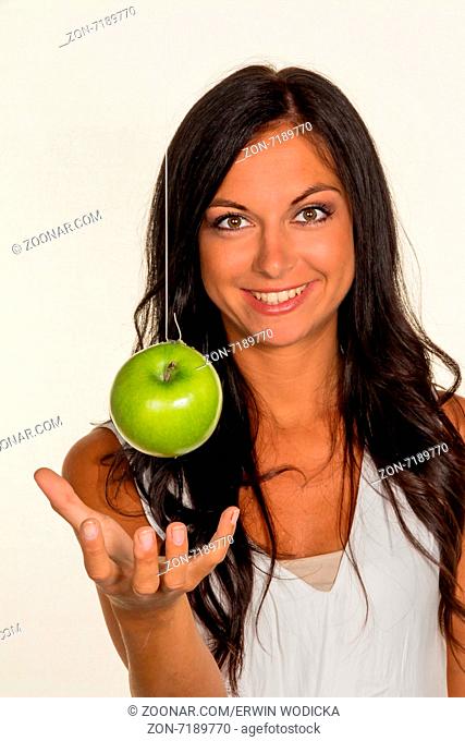 Eine junge Frau hält einen Apfel in der Hand. Obst und Gemüse für gesunde und vitaminreiche Ernährung