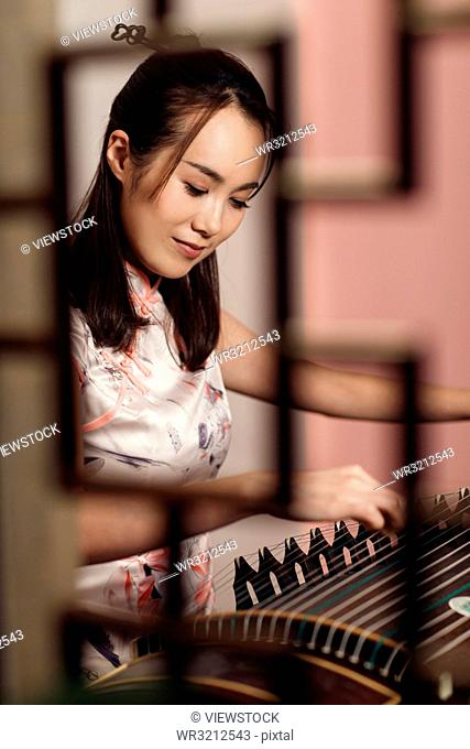 The young woman playing guzheng