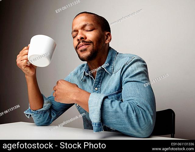 Black young man with coffee cup posing isolated in studio. High quality photo