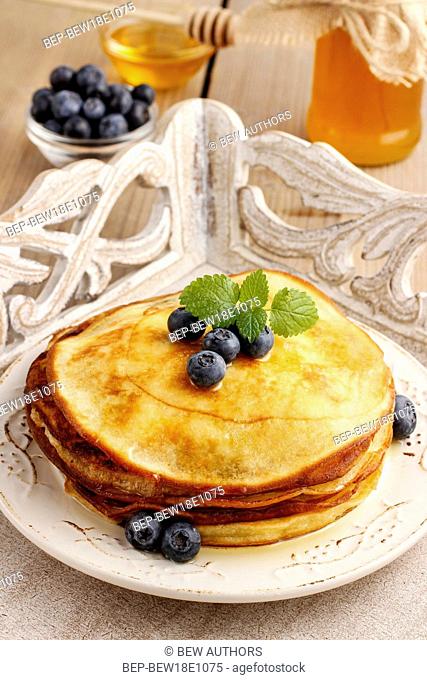 Stack of pancakes with syrup and blueberries. Summer party dessert