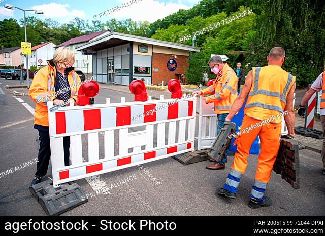 15 May 2020, Saarland, Saarbrücken: Employees of the State Office for Road Construction, with the help of Anke Rehlinger (SPD, l), Minister of Economics, Labor