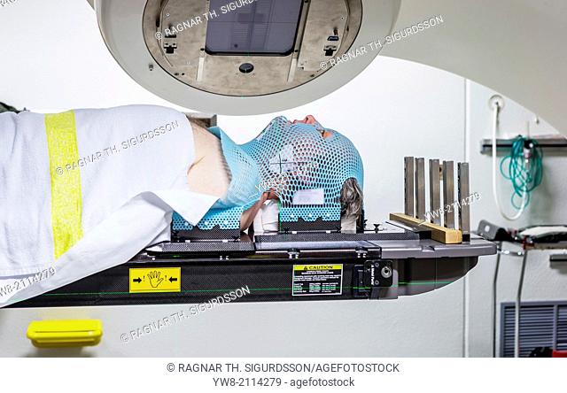 Male cancer patient lying under a linear accelerator or linac receiving radiation treatment. Radiotherapy is the use of high-energy x-rays (and other rays) to...