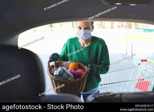 beautiful young blond woman is shopping with mouth nose mask during corona