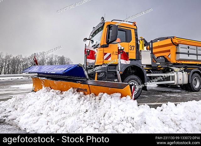 30 November 2023, North Rhine-Westphalia, Lüdenscheid: A clearing vehicle from Autobahn GmbH clears snow from the parking spaces and roadways in a parking lot...