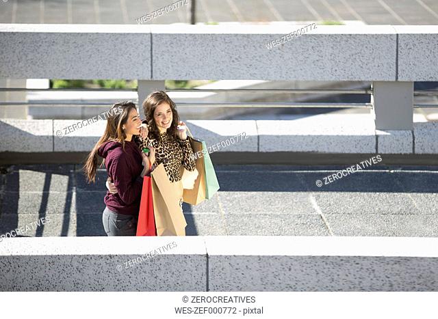 Two happy female friends with shopping bags