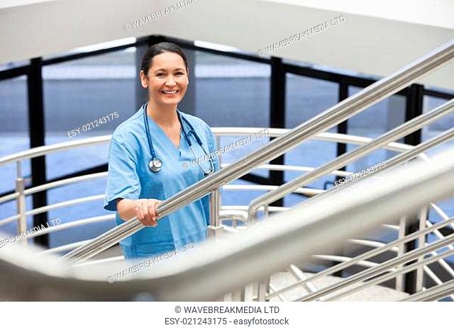 Smiling nurse in a stairwell in hospital corridor