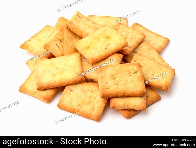 Pile of garlic, rosemary and sea salt crackers isolated on white