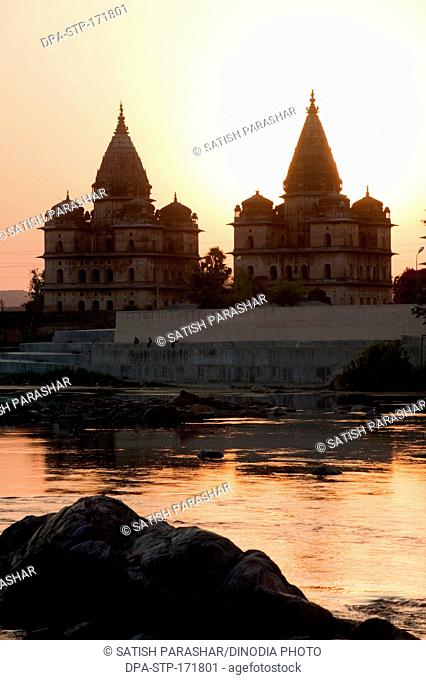 Sunset with cenotaphs at bank of river Betwa , Orchha , Tikamgarh , Madhya Pradesh , India