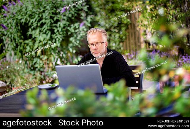 Man using laptop in garden