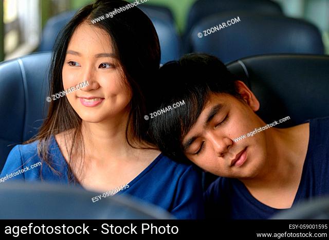 Portrait of young Filipino tourist man and young Asian tourist woman together and in love at Hua Lamphong railway station