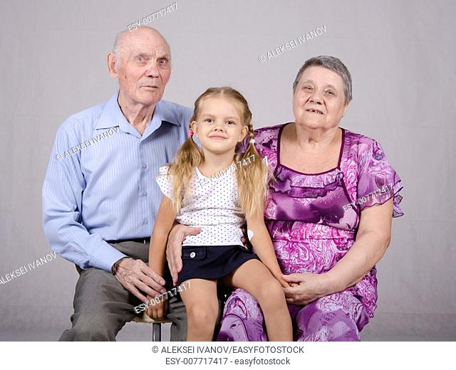 Portrait of an old couple of eighty years old with her granddaughter four years