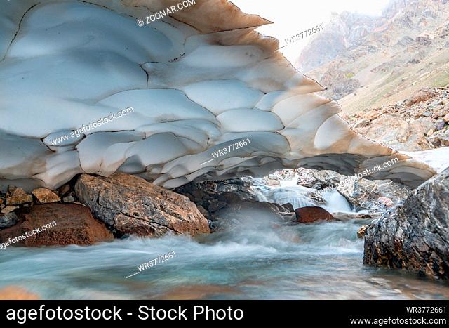 The beautiful view of frozen glacier and Kaznok river neat to Zmeya peak in Fann mountains in Tajikistan