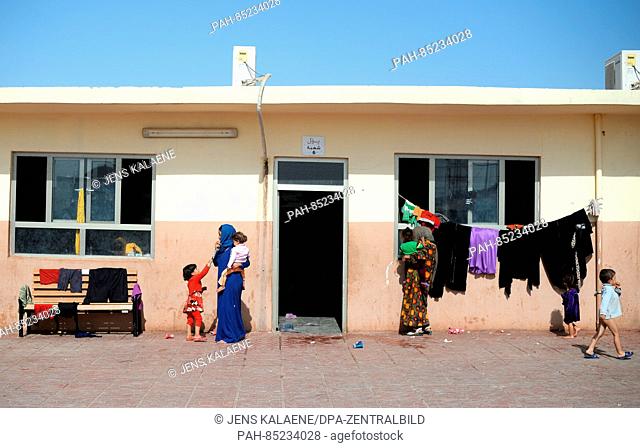 Mothers and their childresn stand outside their accomdations in the Debaga refugee camp between Mosul and Erbil, Iraq, 18 October 2016