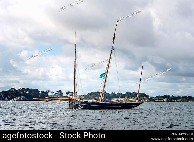 Roscoff, France - July 31, 2018: Old sailing boat in the bay of Roscoff against cloudy sky