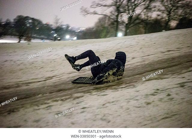 People using anything from sledges, roadworks fences, pallets & bin lids carry on sliding down London's Primrose Hill late into the night