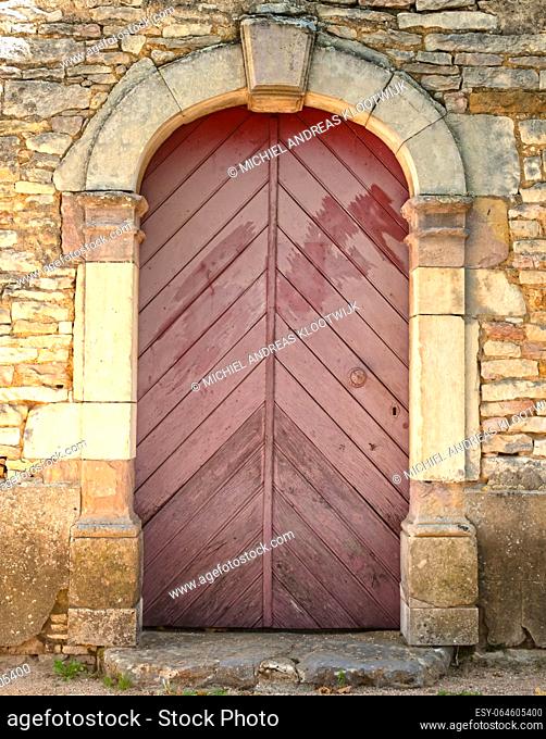 Old wooden door in a building with a stone wall