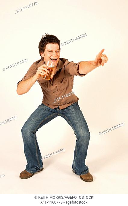 Happy young man drinking a pint of beer lager